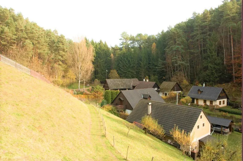 Budovy penzionu v údolí mezi zalesněnými svahy
